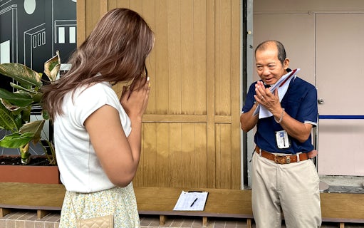 Tour guide greeting visitor with traditional Thai gesture at Wat Phra Kaew, Bangkok.