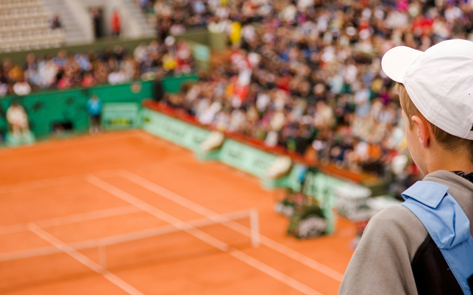 Spectator watching a tennis match at Roland Garros Stadium.