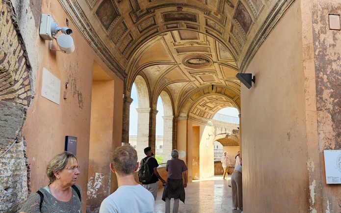 Visitors exploring the arched corridor of Castel Sant'Angelo in Rome.