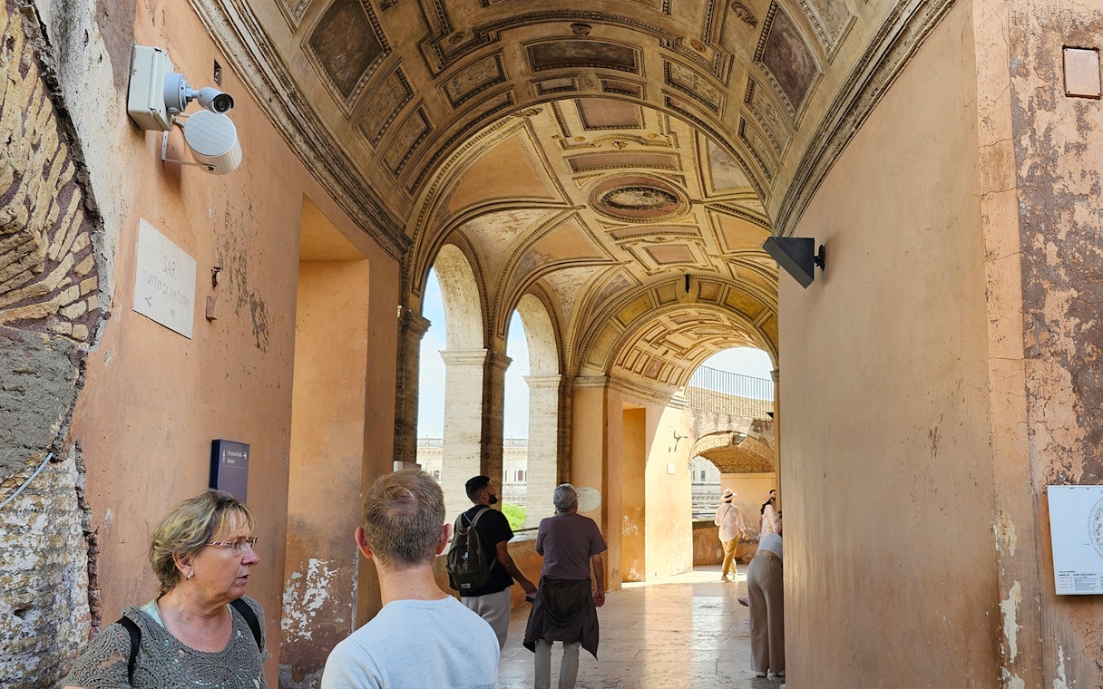 Visitors exploring the arched corridor of Castel Sant'Angelo in Rome.