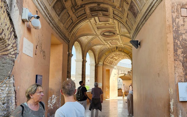 Visitors exploring the arched corridor of Castel Sant'Angelo in Rome.