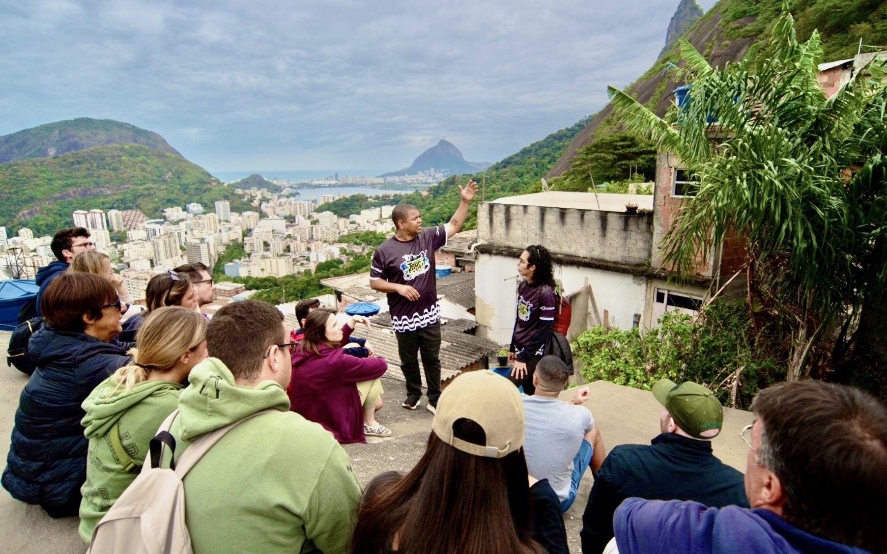 Tourists listening to a guide at a viewpoint overlooking Santa Marta, Rio de Janeiro.