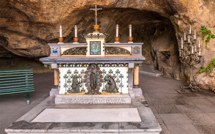 Altar in the Vatican Grottoes with religious statues and candles.