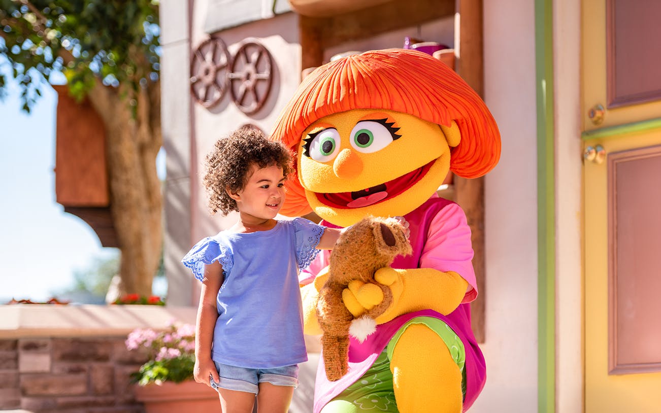 Child interacting with a costumed character at Sesame Place Philadelphia.