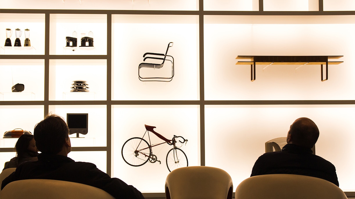 People sitting down in front of an exhibit of designer items at Museum Brandhorst.