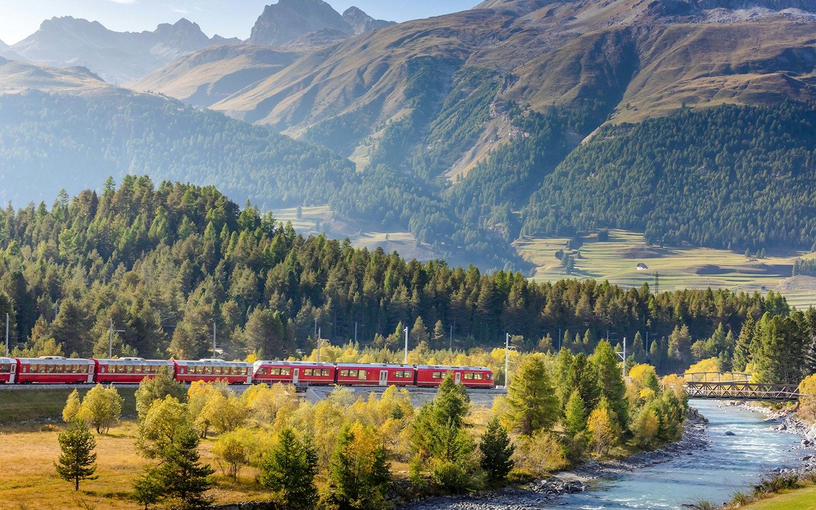 Swiss train in the alps and river around Bernina pass, Engadine, Switzerland