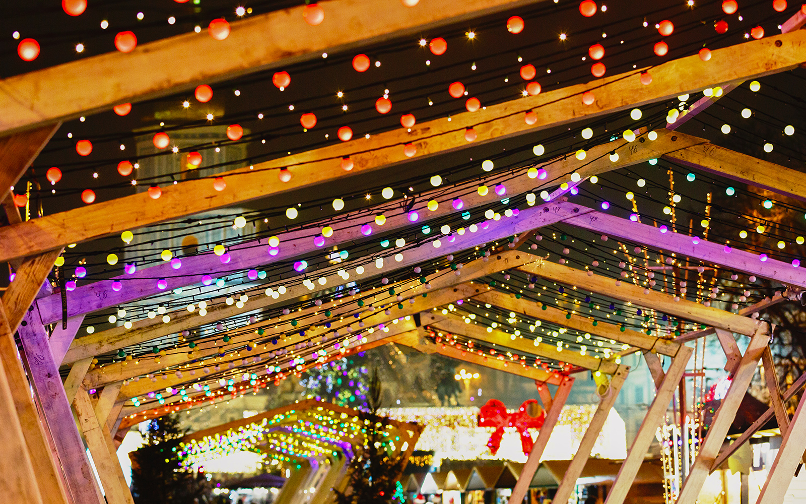Poble Espanyol Barcelona New Year lights under wooden arches.
