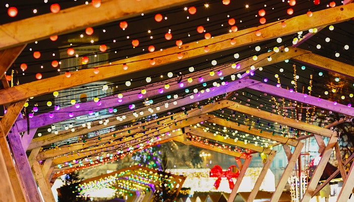 Poble Espanyol Barcelona New Year lights under wooden arches.