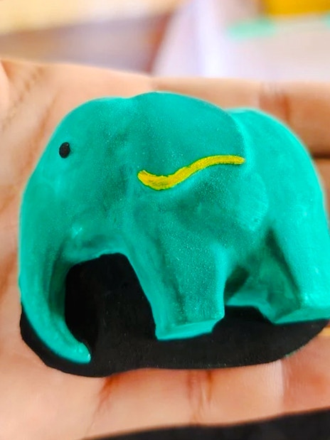 Painted elephant figurine in hand at Phuket Elephant Care.