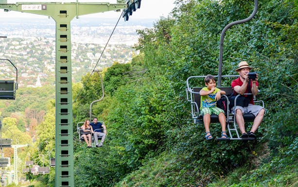 Guests on chairlift ride during Janos Hill Lookout Tower tour, Budapest.