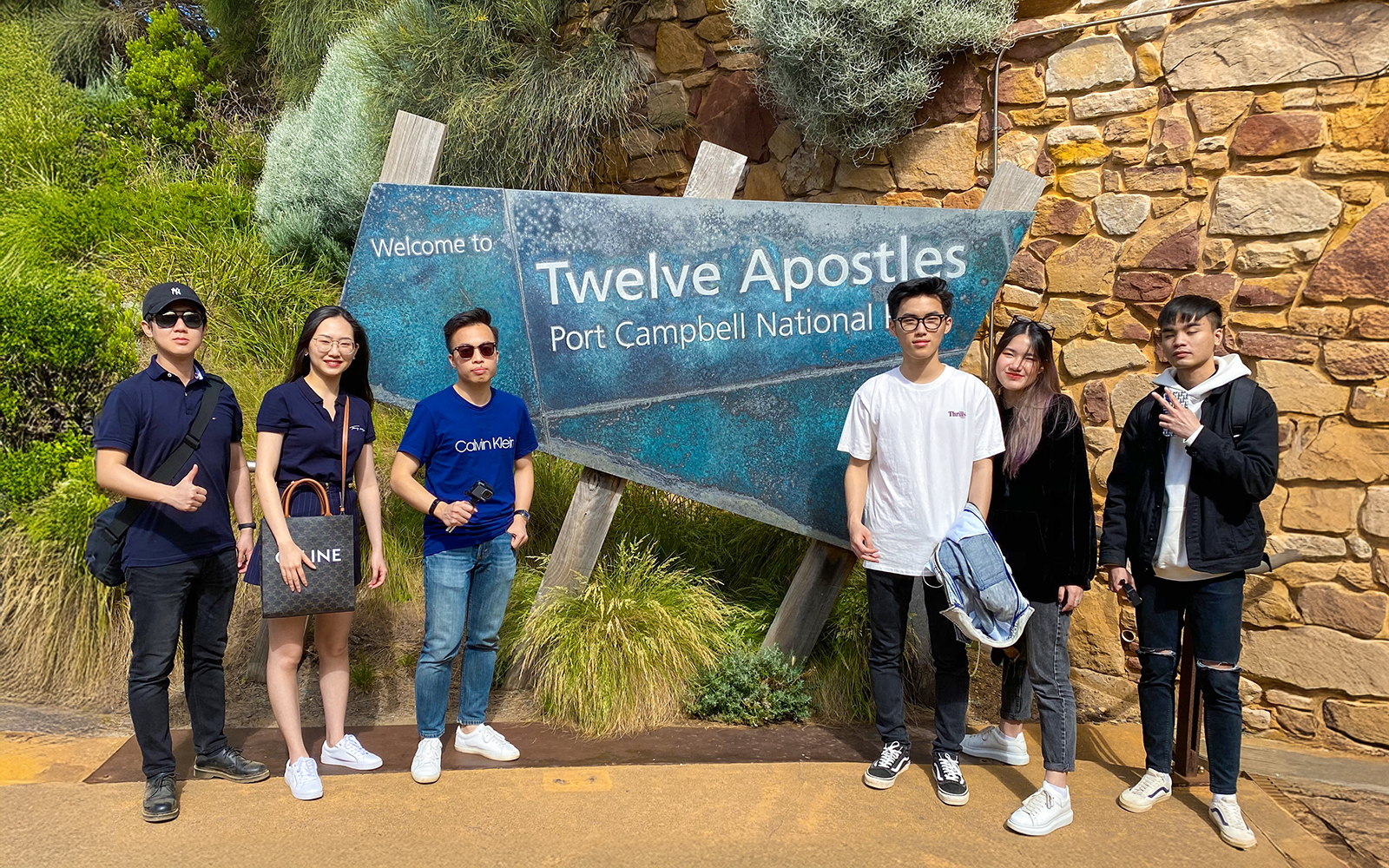 Twelve Apostles sign with people on Great Ocean Road, Melbourne.