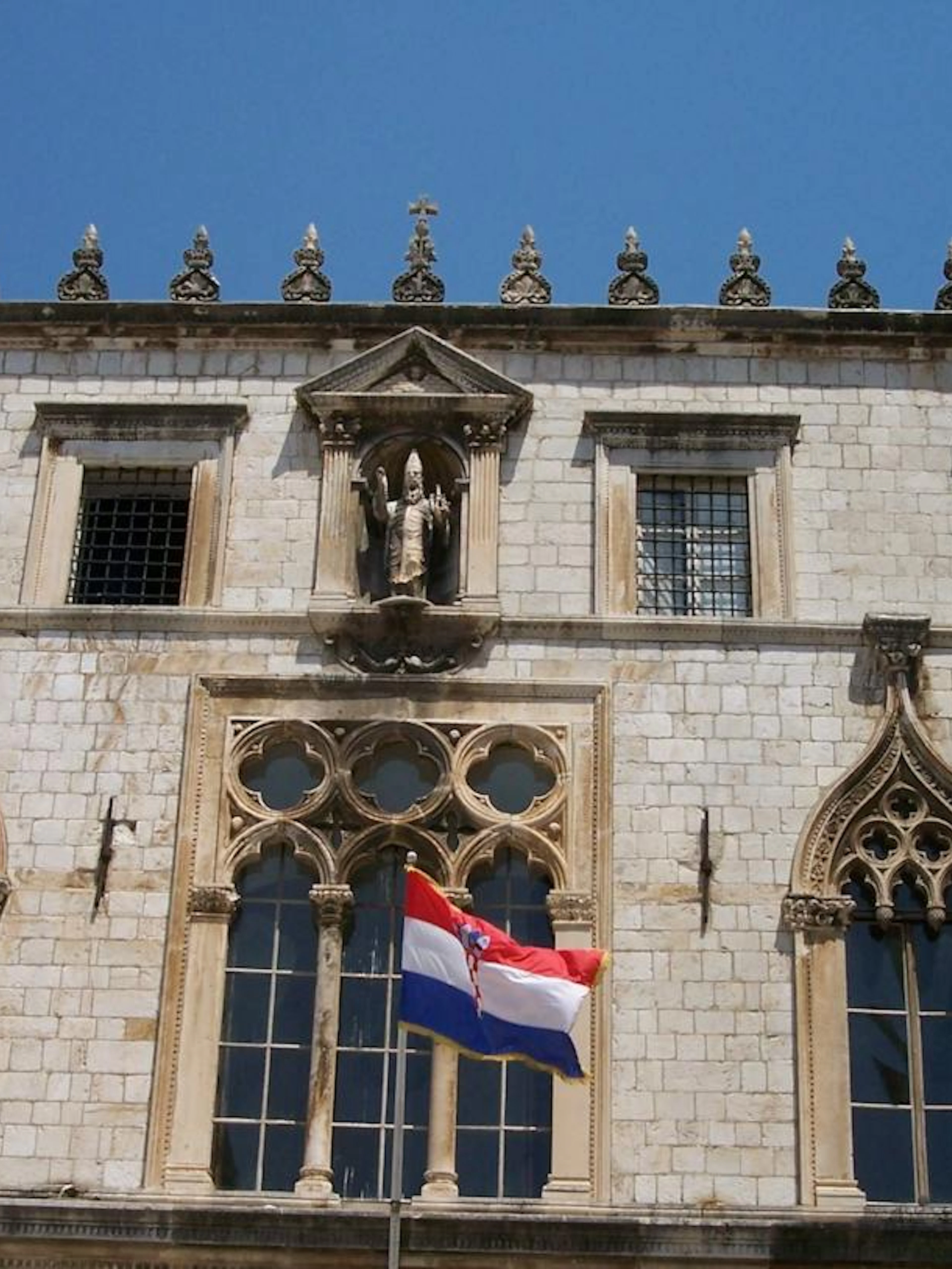 Dubrovnik Old Town building facade with Croatian flag, part of self-guided audio walk.