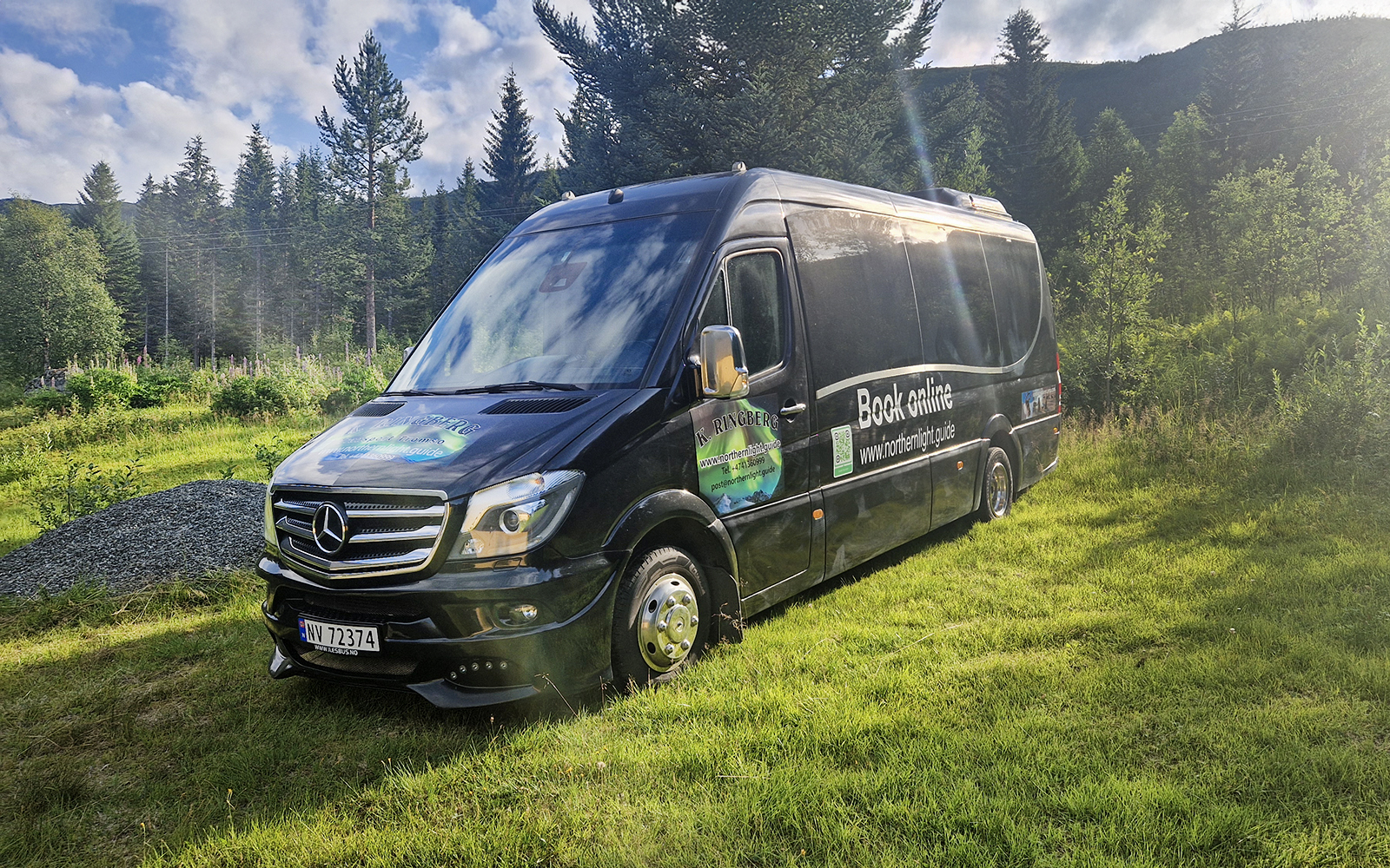 Van used for transfers during Arctic Whale Watching from Tromsø to Skjervøy, parked in a forested area.