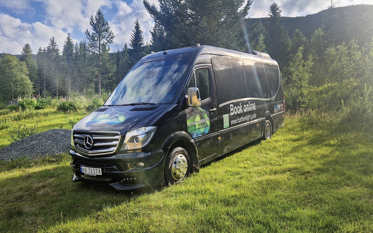 Van used for transfers during Arctic Whale Watching from Tromsø to Skjervøy, parked in a forested area.