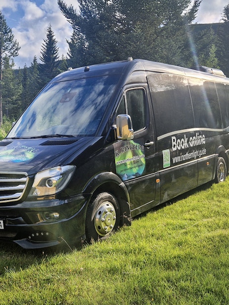 Van used for transfers during Arctic Whale Watching from Tromsø to Skjervøy, parked in a forested area.