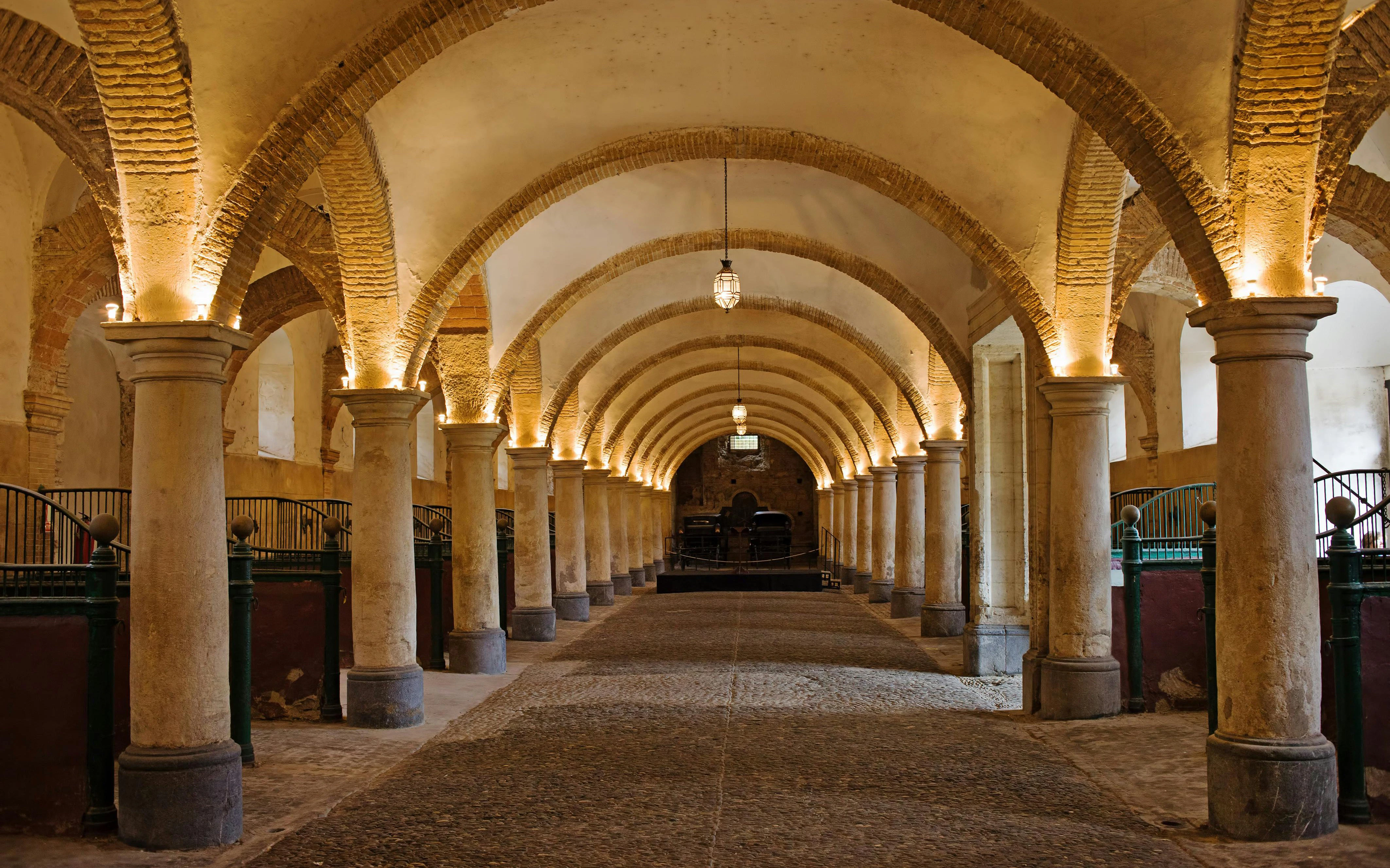 Royal Stables in Cordoba with arched ceilings and stone columns.