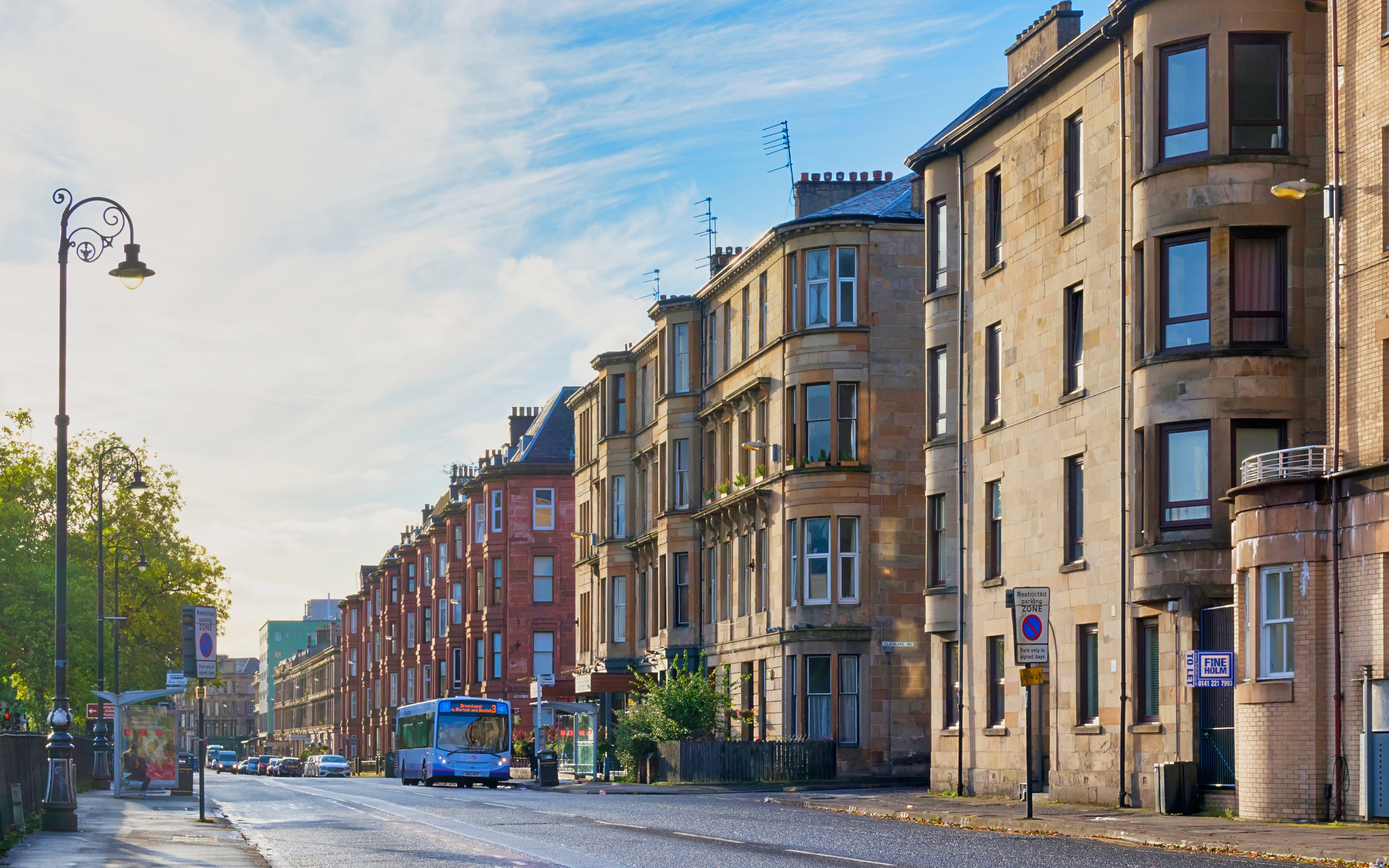 Sauchiehall Street in Glasgow with historic tenement buildings and a city bus.