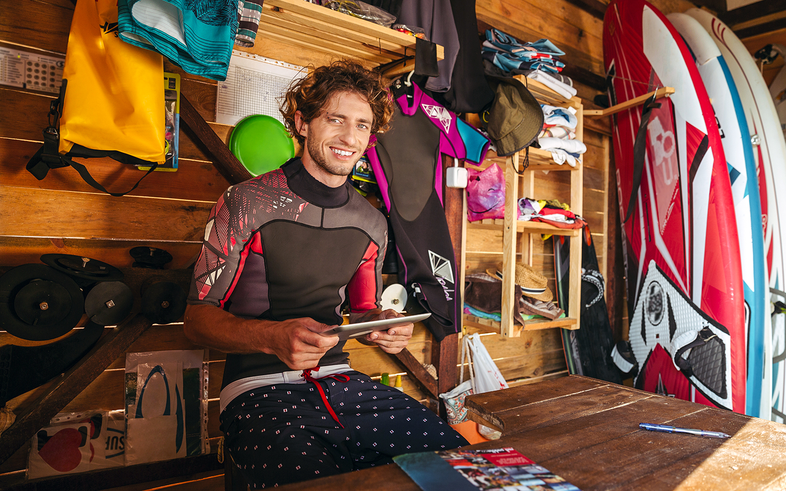 Man browsing swimwear at a surf shop in a coastal city.