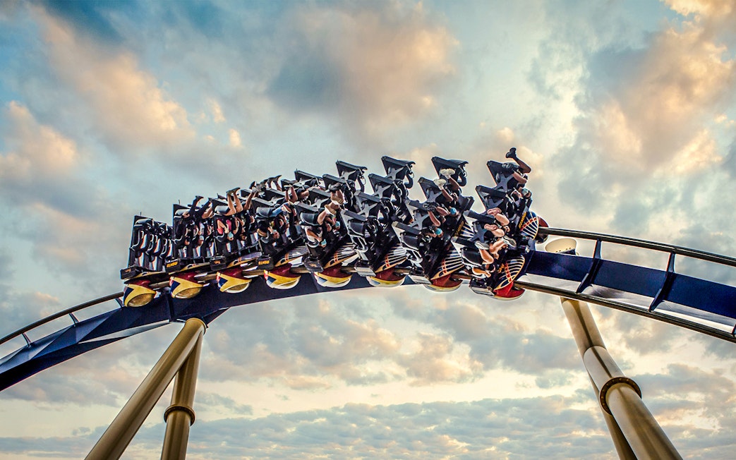 Roller coaster with riders at Busch Gardens against a cloudy sky.