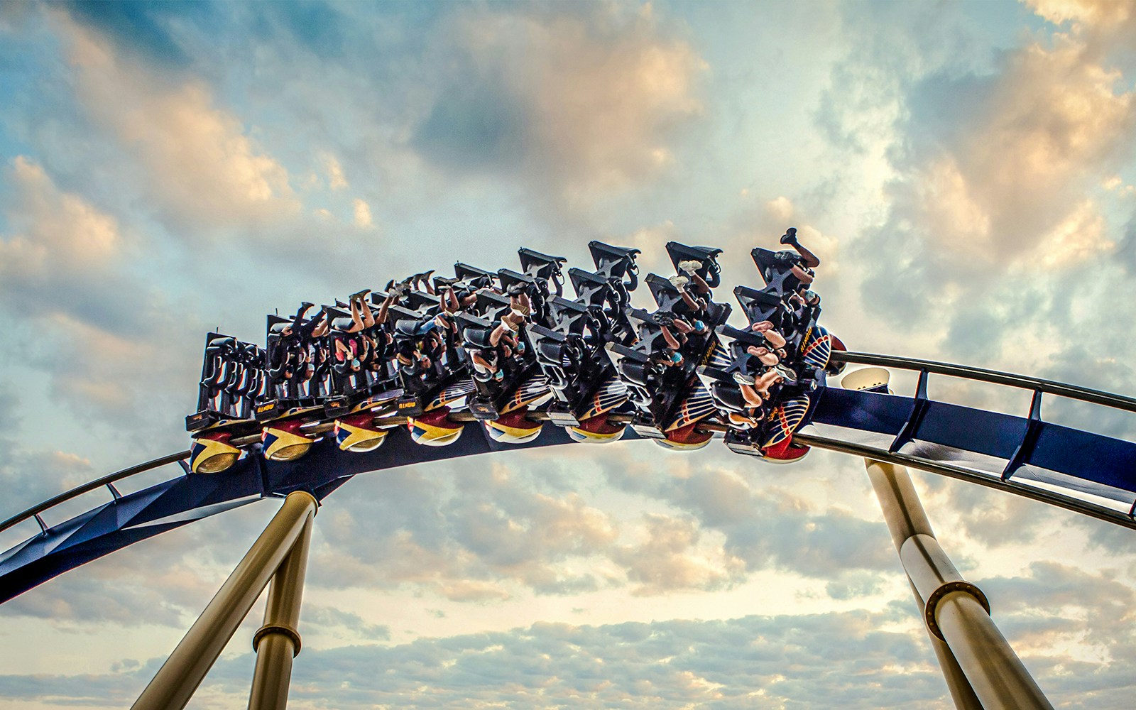 Roller coaster with riders at Busch Gardens against a cloudy sky.