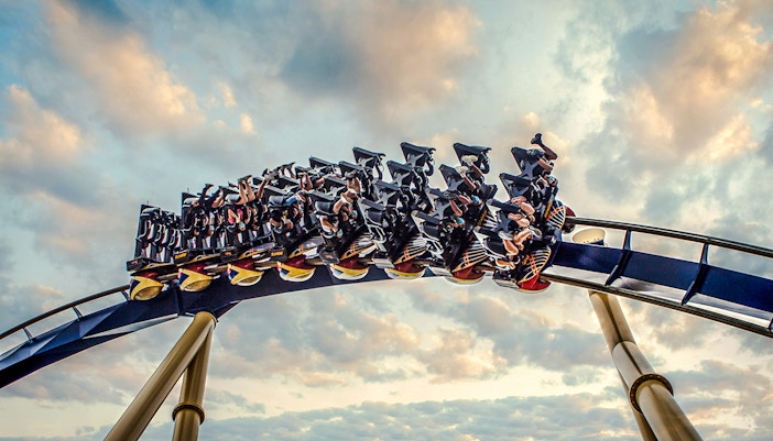 Roller coaster with riders at Busch Gardens against a cloudy sky.