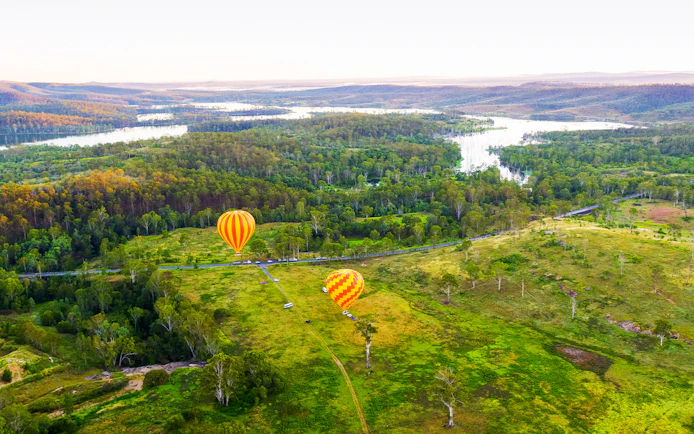 Hot air balloons over lush landscape, Gold Coast, Australia.