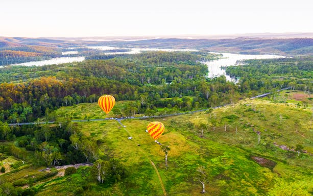 Hot air balloons over lush landscape, Gold Coast, Australia.