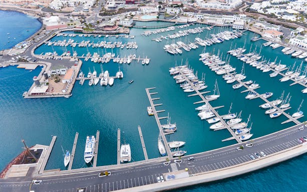 Aerial view of a marina in Lanzarote with boats docked, starting point for ferry to Fuerteventura.