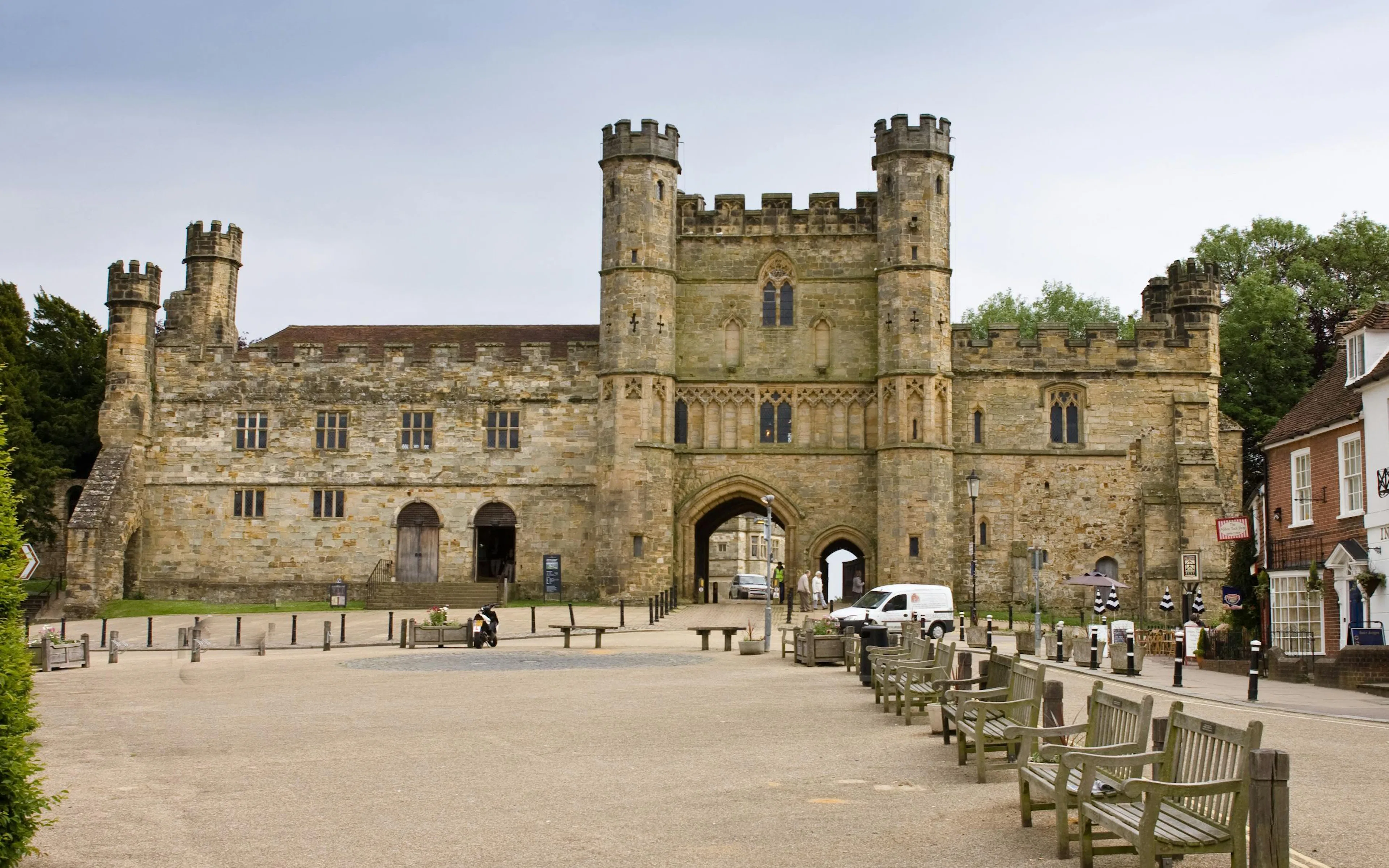 Battle Abbey entrance with stone towers and archway in East Sussex, England.