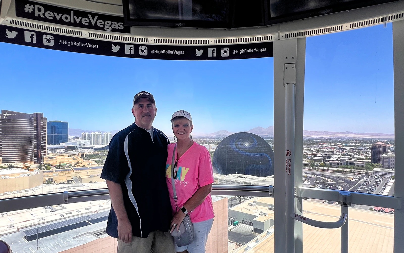 Guests posing inside High Roller gondola with Las Vegas skyline view.