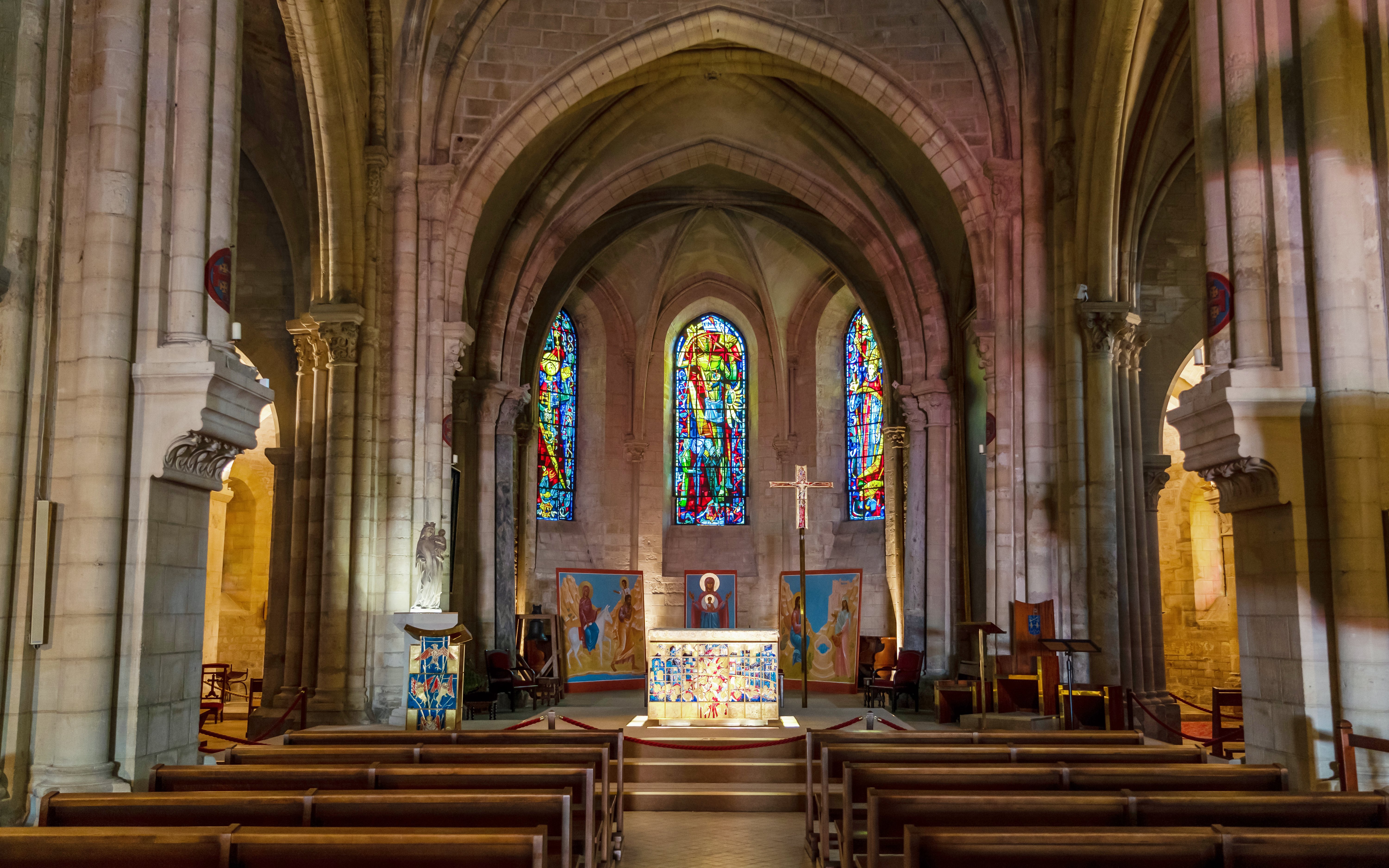 Interior of Church of Saint-Pierre Mont Saint Michel with stained glass windows and altar.