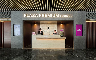 Plaza Premium Lounge reception with staff at the counter.