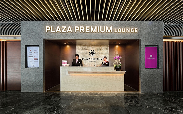 Plaza Premium Lounge reception with staff at the counter.