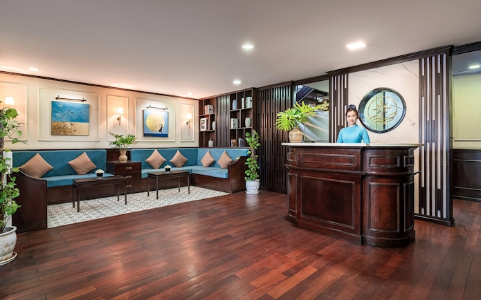 Reception area with wooden desk and seating at Amanda Luxury Cruise.