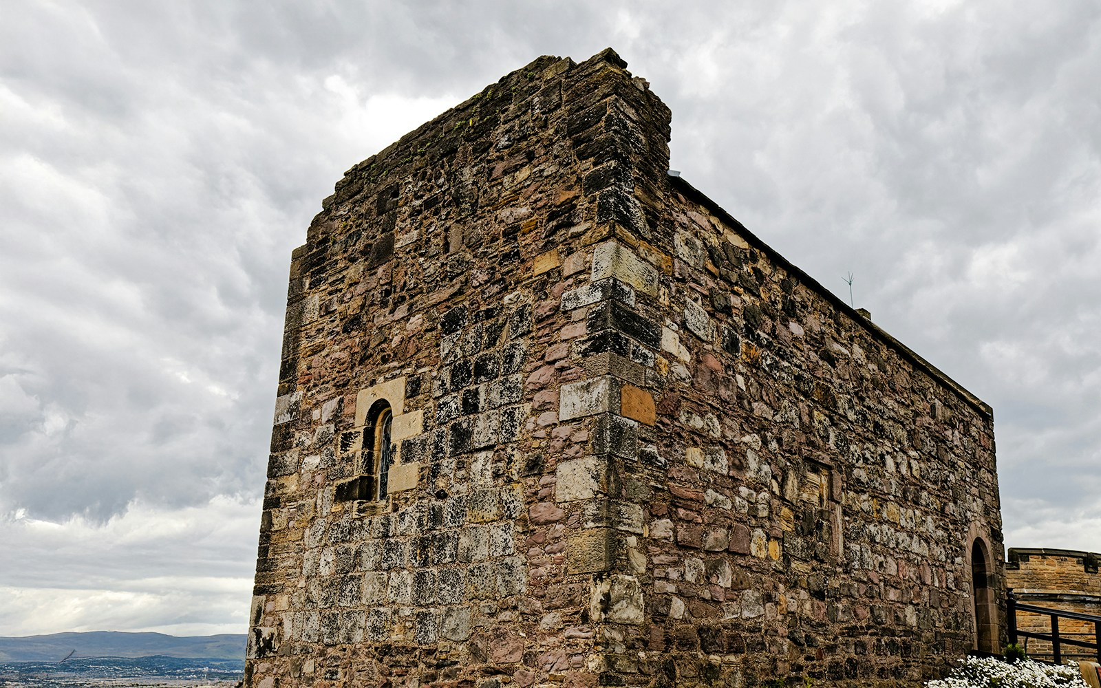 St Margaret's Chapel at Edinburgh Castle, historic stone structure under cloudy sky.
