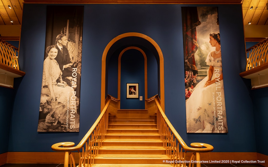 Staircase leading to The King's Gallery at the Palace of Holyroodhouse, featuring royal portraits.