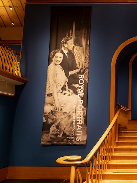 Staircase leading to The King's Gallery at the Palace of Holyroodhouse, featuring royal portraits.