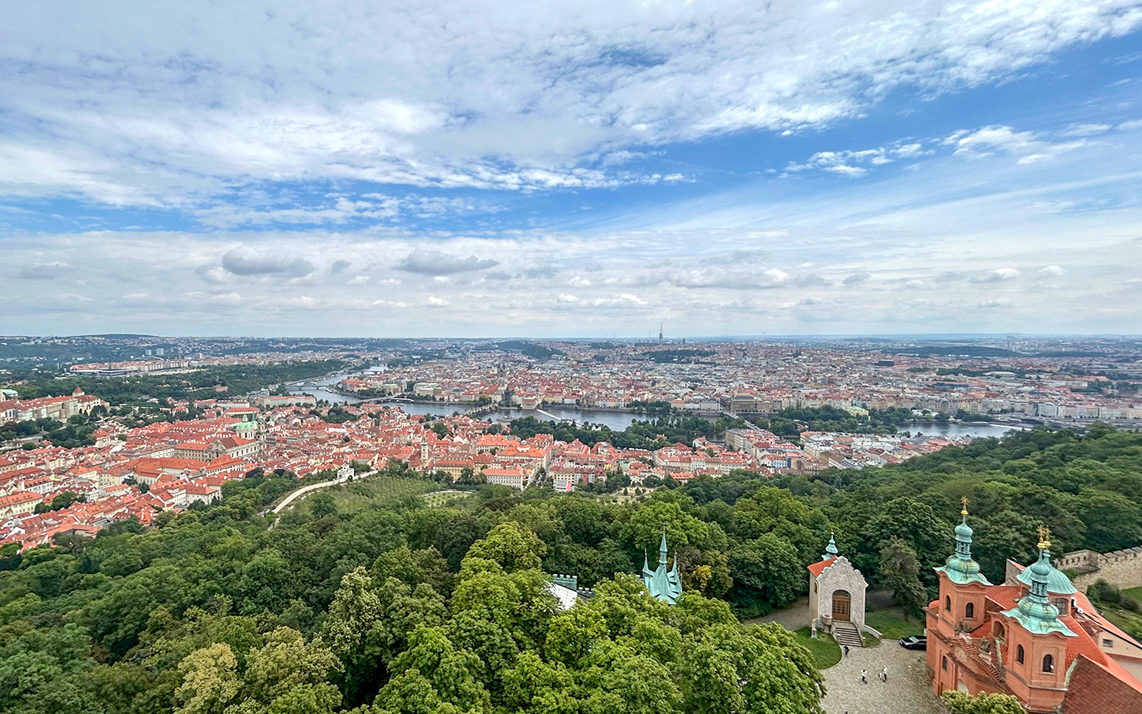 Prague cityscape from Petrin Tower with Vltava River and historic buildings.