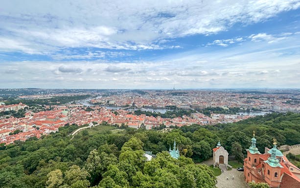 Prague cityscape from Petrin Tower with Vltava River and historic buildings.