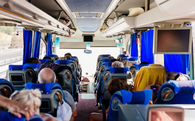 Passengers seated inside an air-conditioned tour bus.