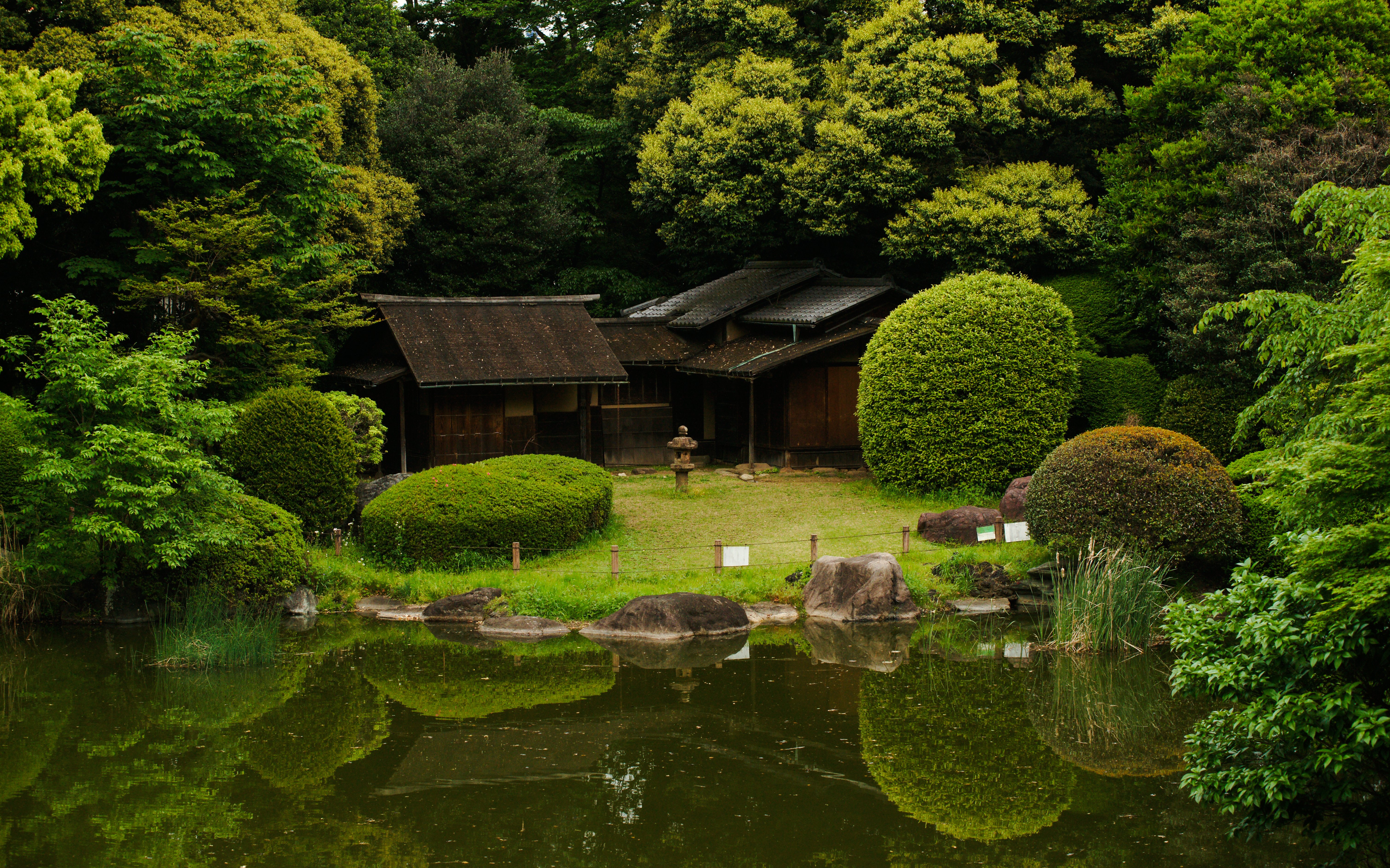 Japanese garden with traditional wooden structures behind Tokyo National Museum in Ueno Park.