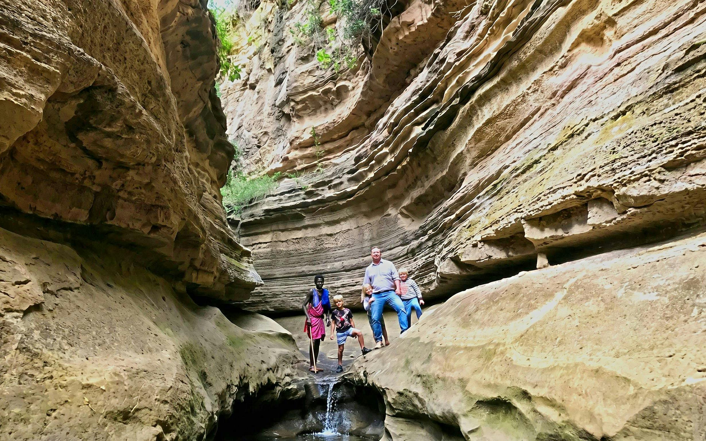 Visitors exploring narrow gorge on guided tour of Hell's Gate, Nairobi.