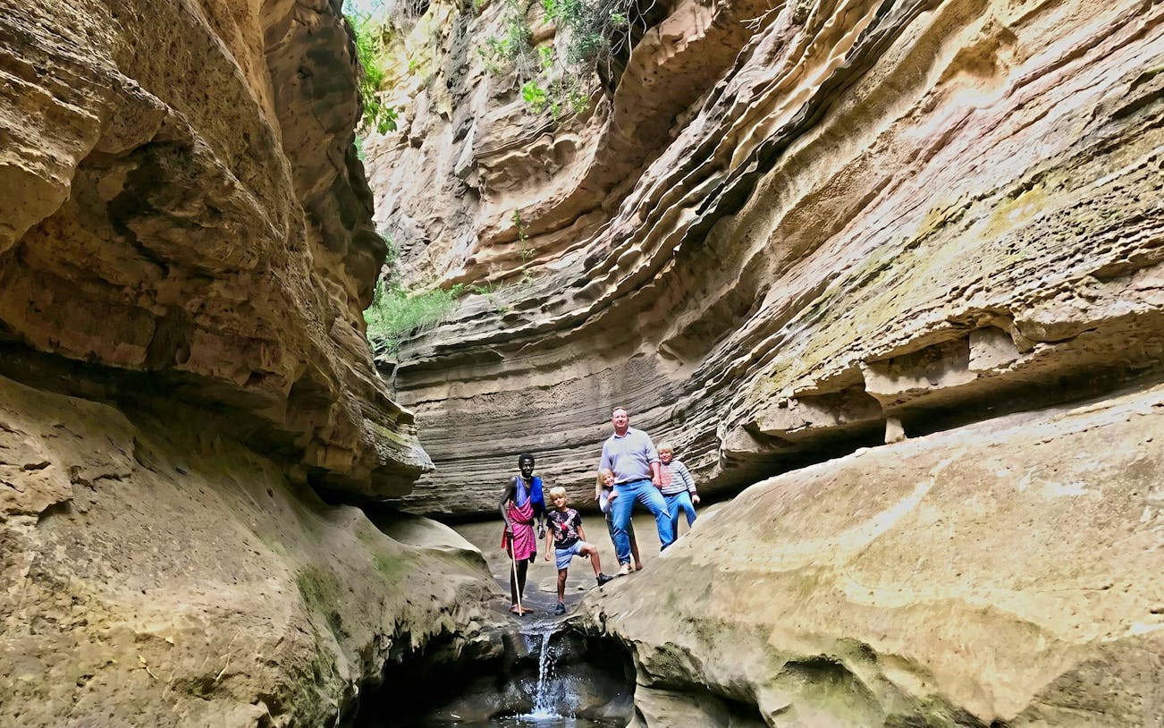Visitors exploring narrow gorge on guided tour of Hell's Gate, Nairobi.