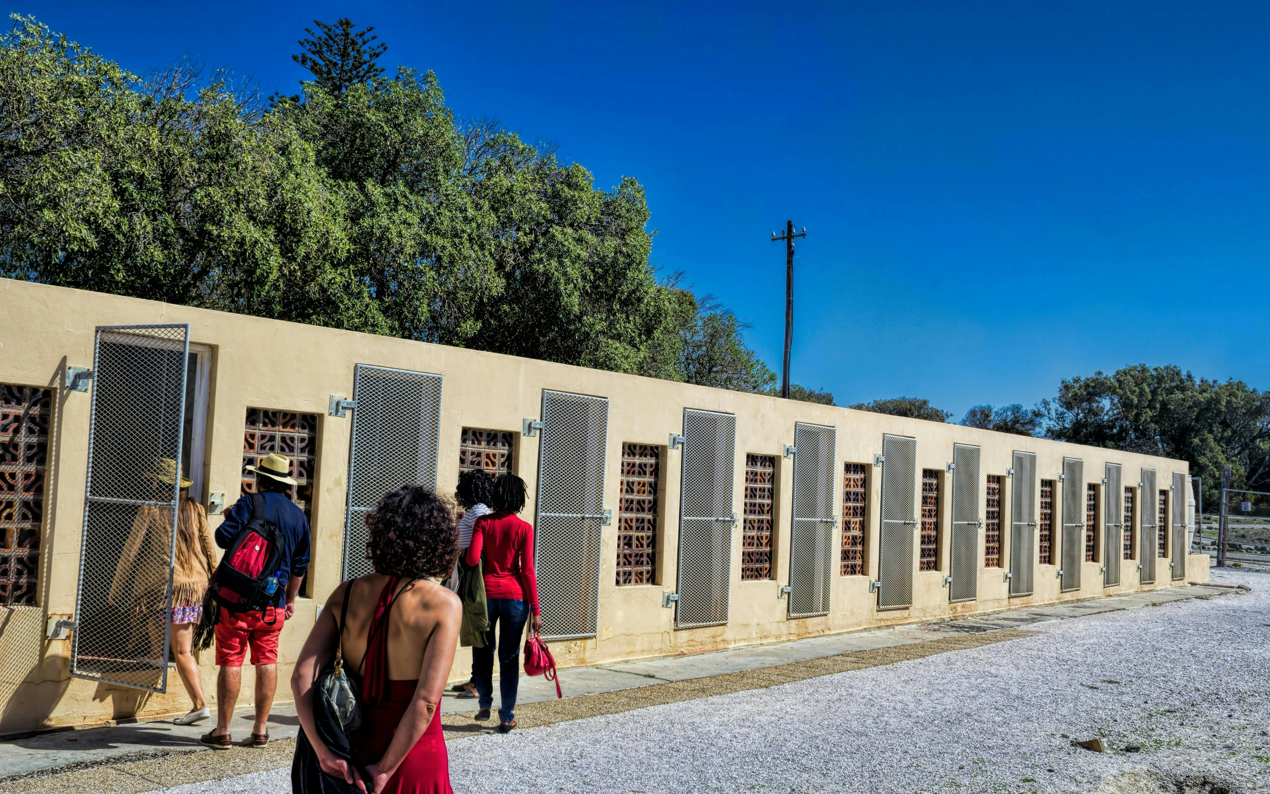 Visitors exploring prison cells on Robben Island, South Africa.