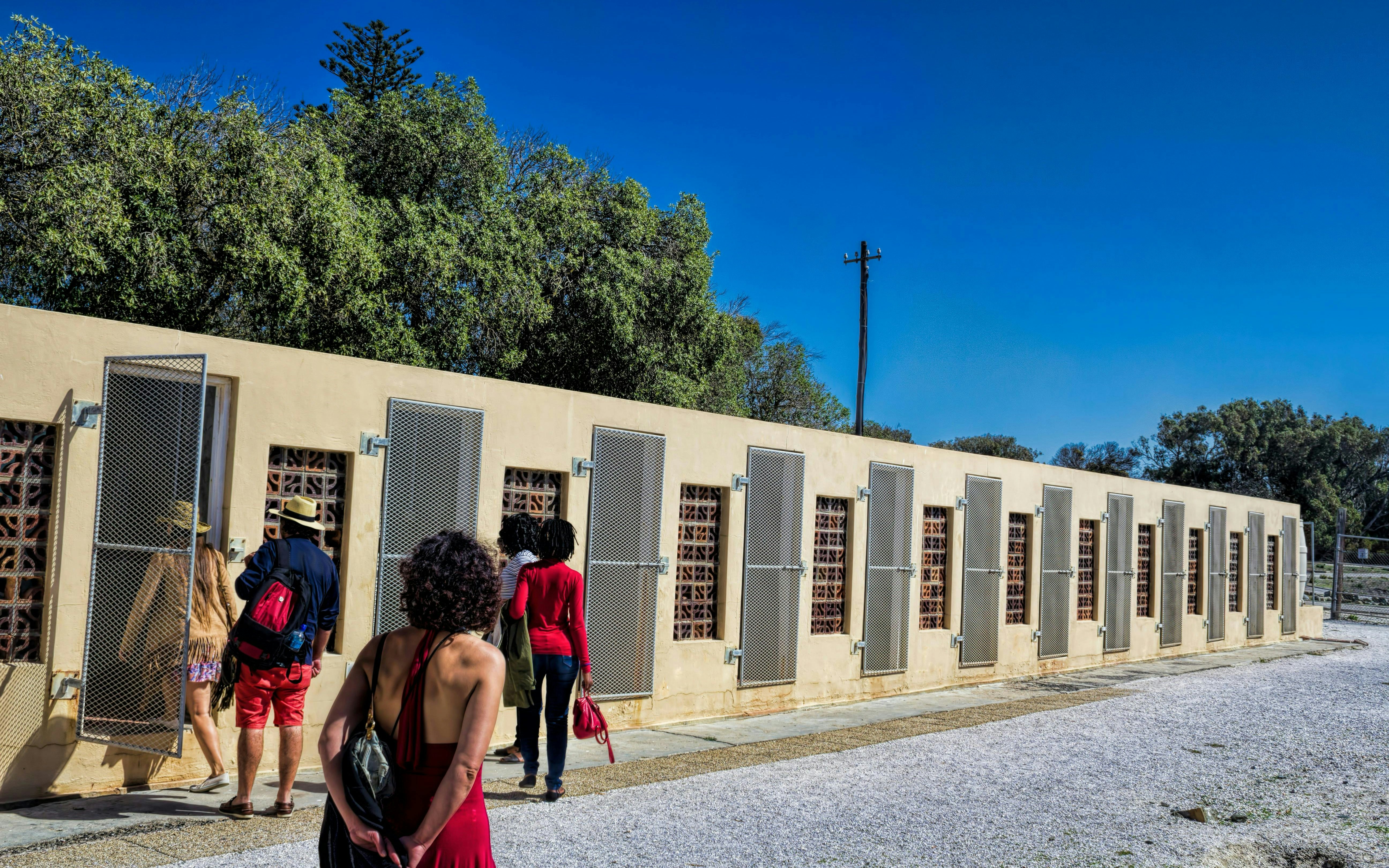 Visitors exploring prison cells on Robben Island, South Africa.