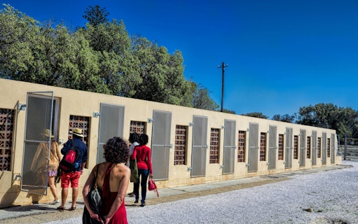 Visitors exploring prison cells on Robben Island, South Africa.