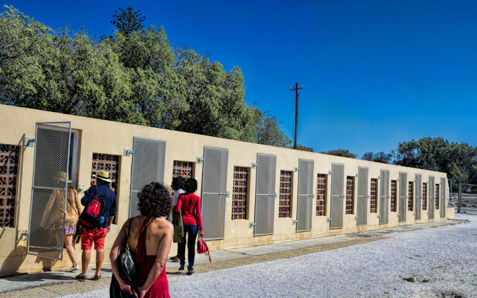 Visitors exploring prison cells on Robben Island, South Africa.