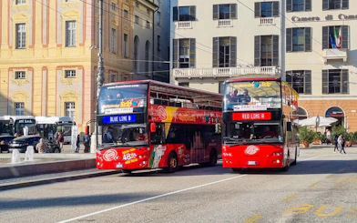 Hop-on hop-off tour buses in Genoa city center.