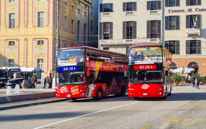 Hop-on hop-off tour buses in Genoa city center.