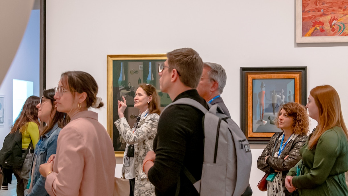 Guide explaining Picasso exhibition at Tate Modern to a group of visitors.